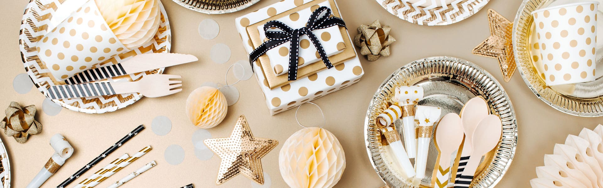 Sand-Creek-Crossing-Page-Banner-Party-Teller Picture of a variety of silver and gold party decorations on a table