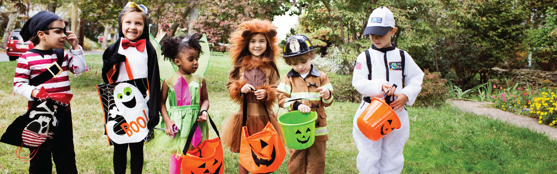 sc-sprit-hallween-header Multiple children wearing Halloween costumes and holding candy bags